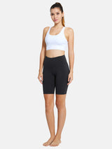 Woman in dark grey 7" high waist yoga shorts and white sports bra, perfect for yoga and workouts. #color_Gray