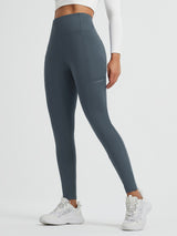 Running Cross Pocket Fleece Tight Leggings in dark grey with side pockets and white sneakers. #color_Charcoal Gray