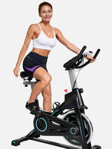 Women's black V-waist cycling shorts with purple accent, worn while riding stationary bike. #color_Purple