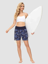 Women's 5-inch blue floral print quick-dry swim board shorts with high waist, posing with surfboard. #color_Print 1