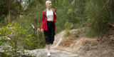 Woman hiking in black capri pants and red jacket