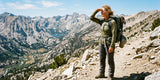 Woman hiking in UPF pants on a sunny mountain trail