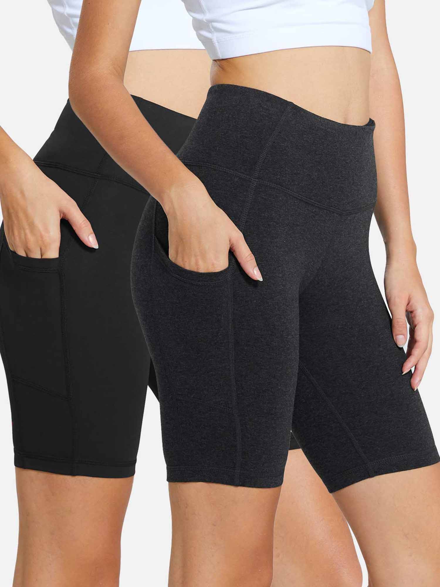Two pairs of women's high-waisted yoga shorts in black and charcoal grey, featuring side pockets. #color_Black/Gray