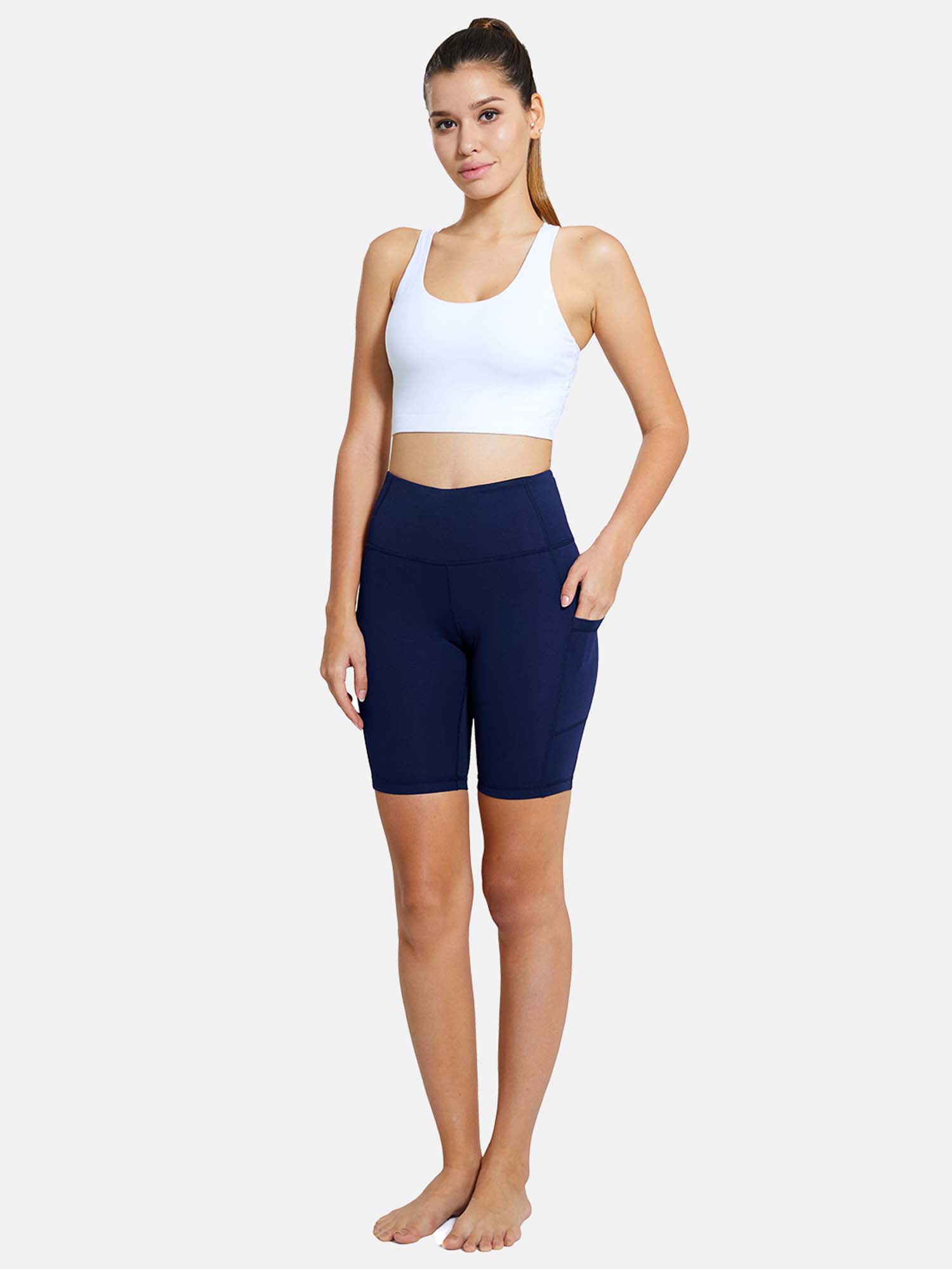 Navy blue 7" yoga high waist comfort shorts with pockets, worn by a model in a white sports bra. #color_Blue