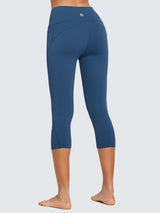 Women's plus size high-waisted blue capri leggings with side pockets and central seam. #color_Blue