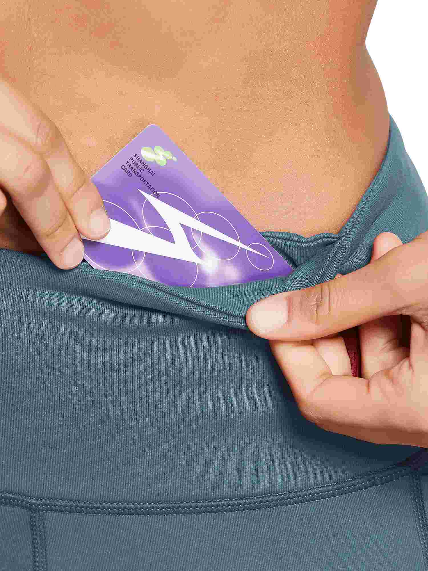 Women's high-waisted capris pocket holds Shanghai transportation card.