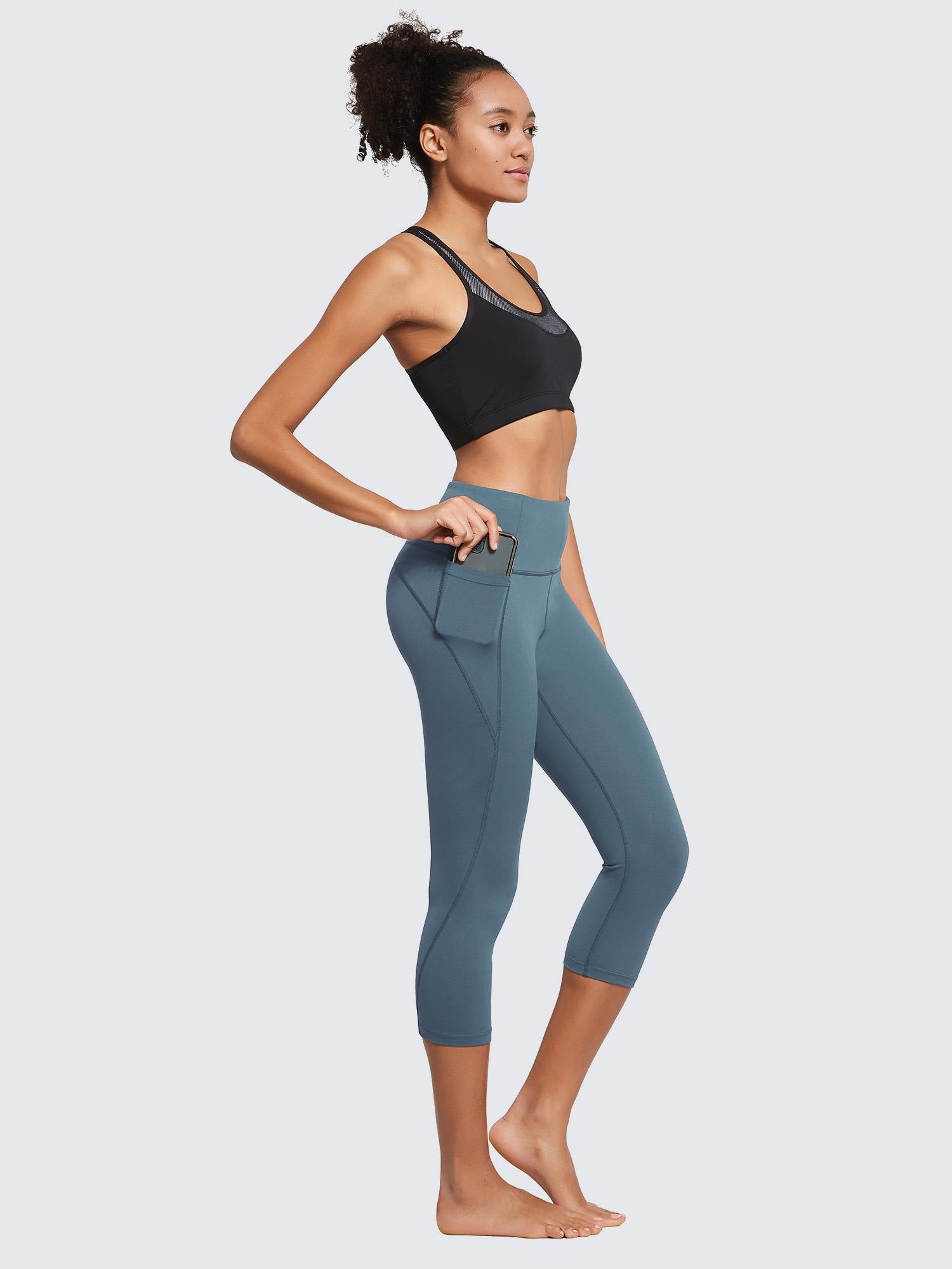 Women's plus size high-waisted blue capri leggings showing side pocket detail and phone storage. #color_Blue