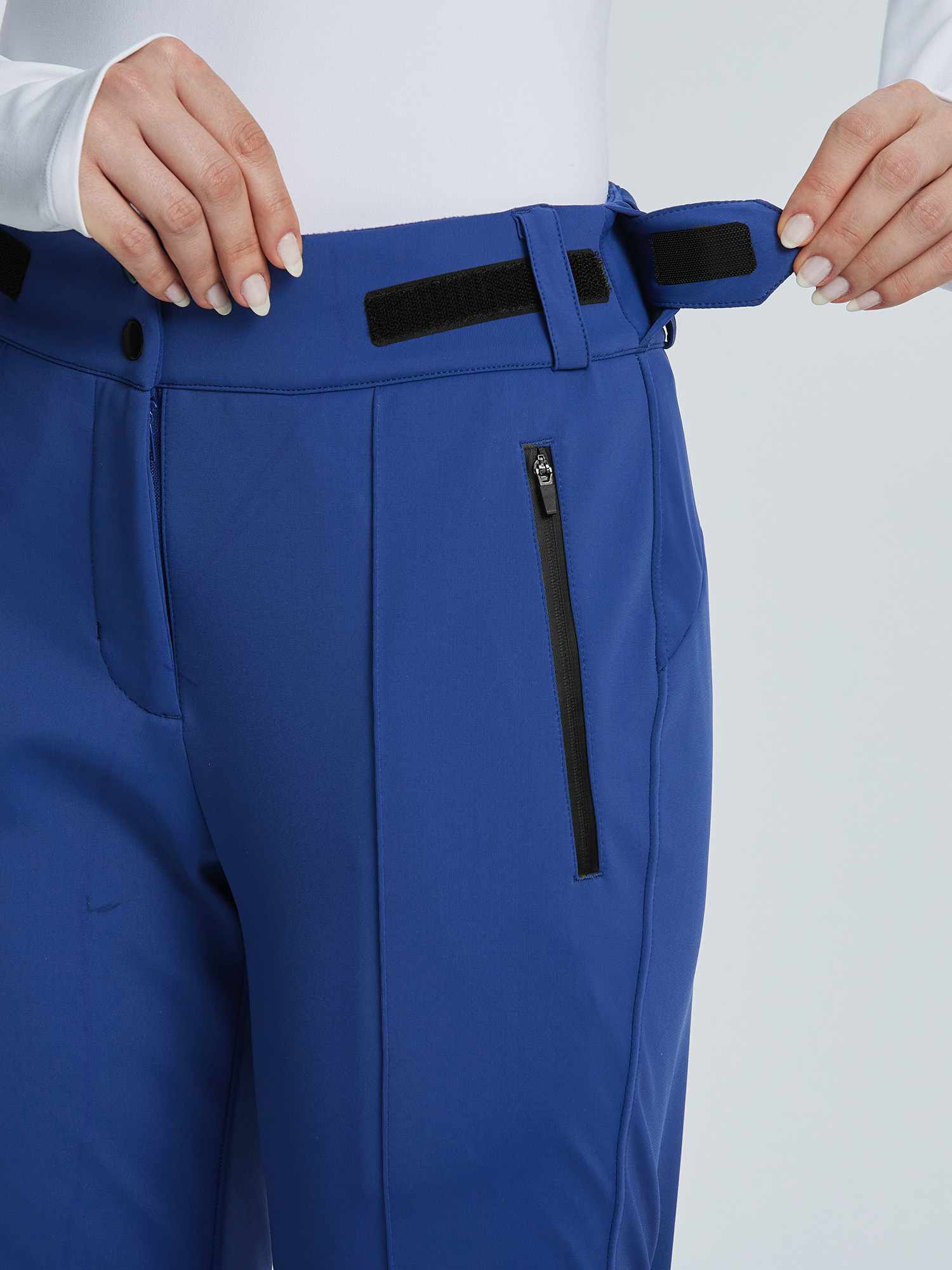 Blue soft-shell ski pants detail: adjustable velcro waistband and waterproof zip pocket. #color_Navy Blue