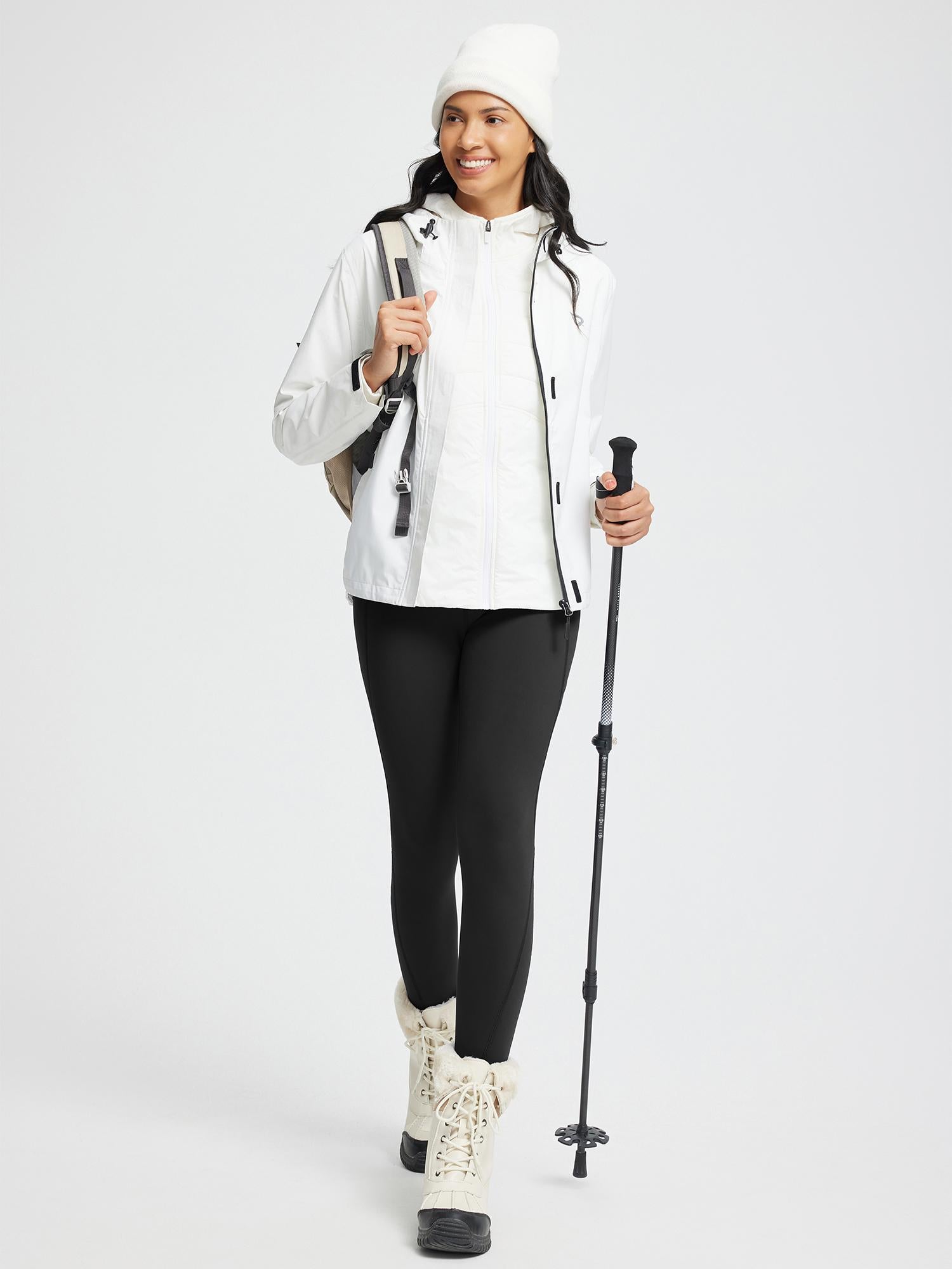 Smiling model in black thermal knit leggings with trekking poles and winter gear. #color_Black