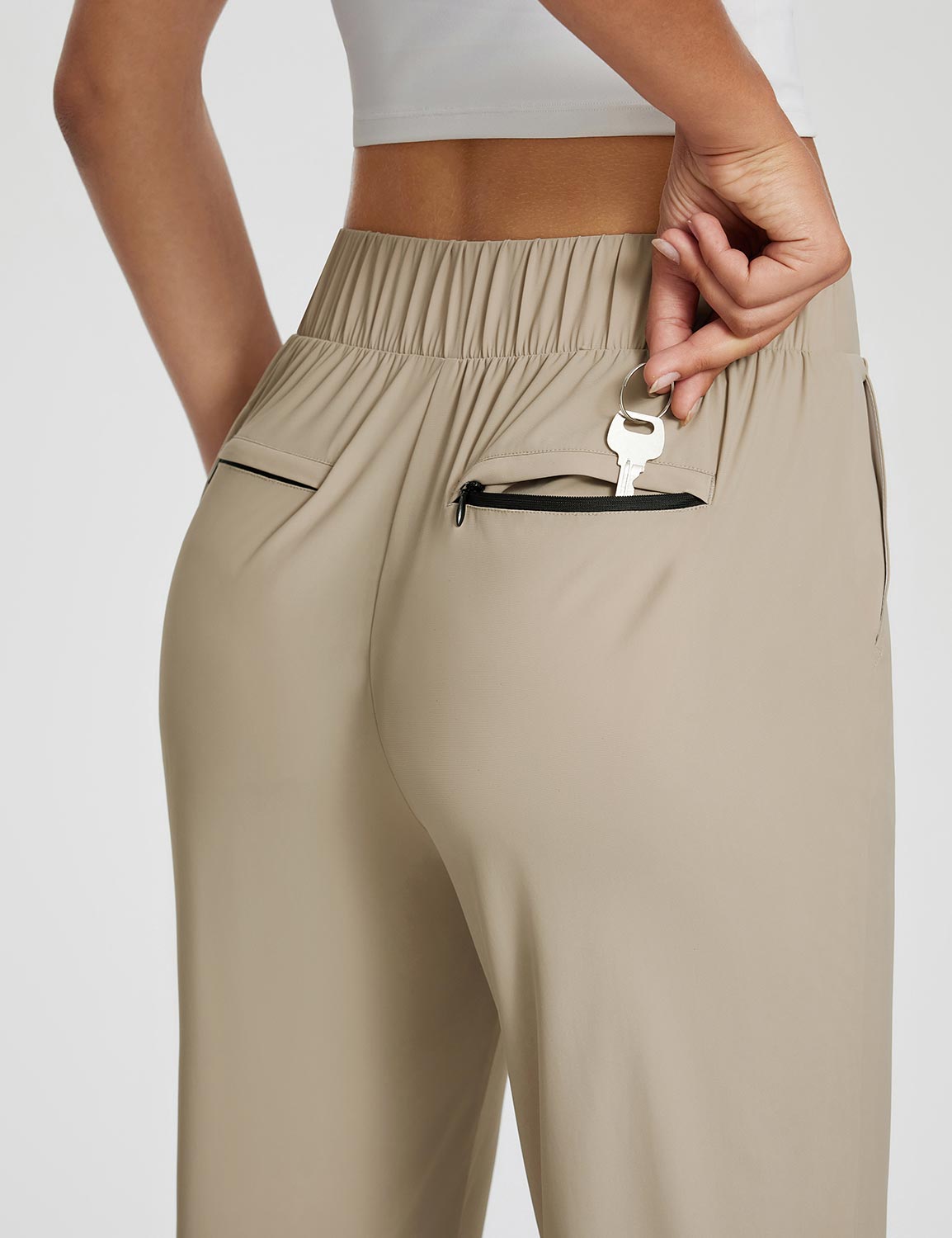 Adventure-ready active pants in tan, featuring a zippered key pocket. #color_Khaki