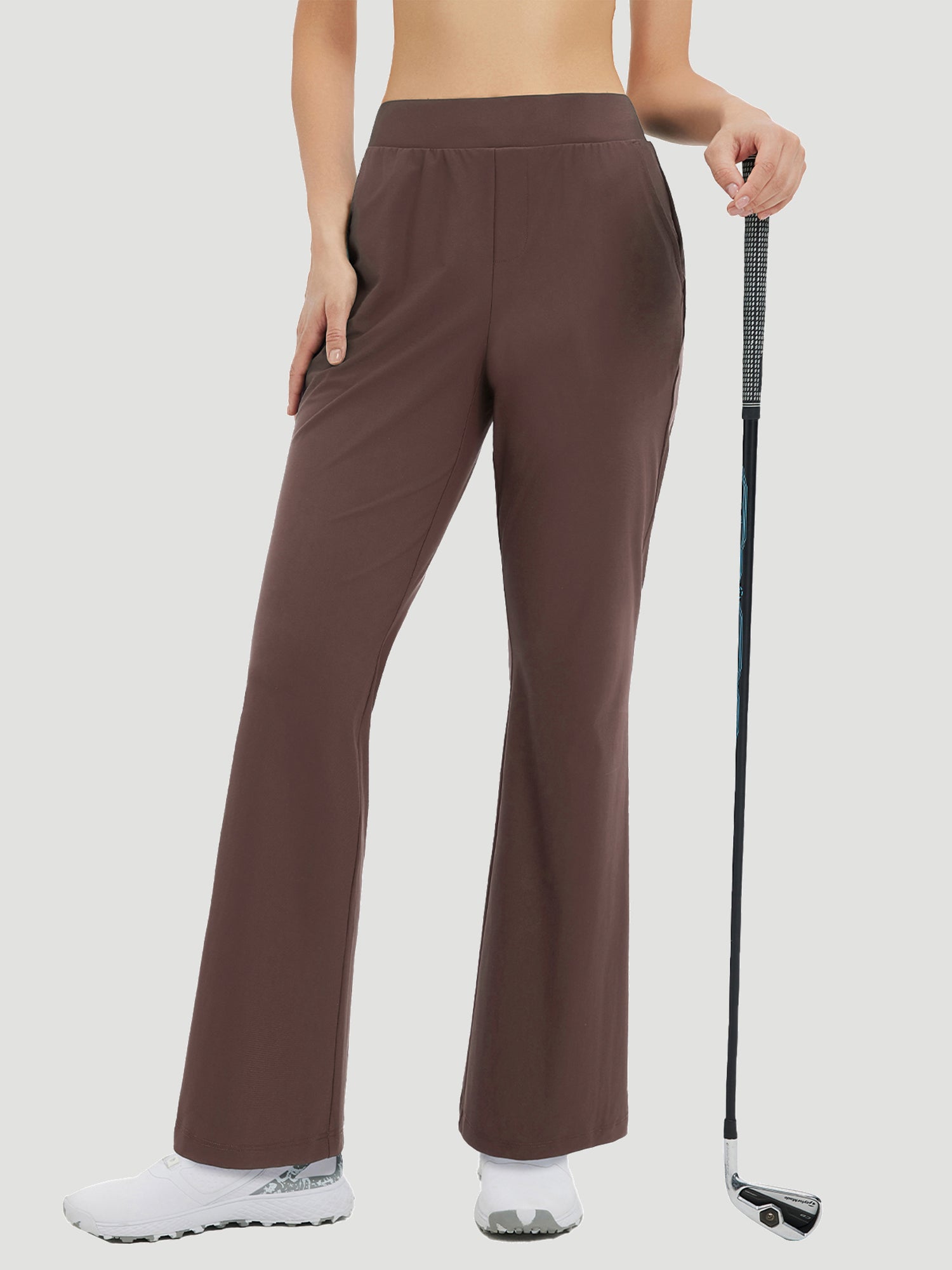 Women's brown flare golf pants, 29" inseam, stretchy nylon spandex, holding golf club. #color_Dark Brown