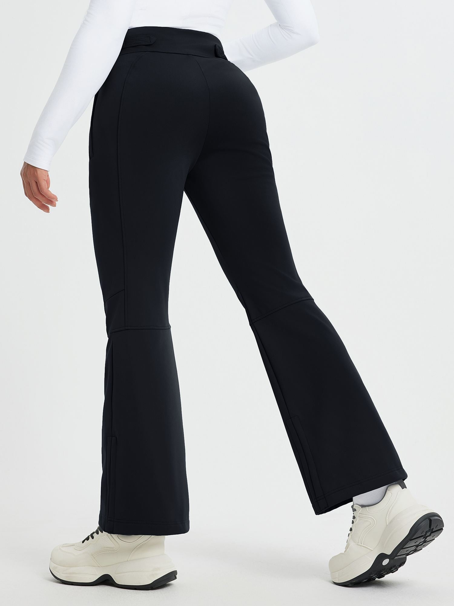 Women's black softshell ski pants with articulated knees and flared leg openings. #color_Black