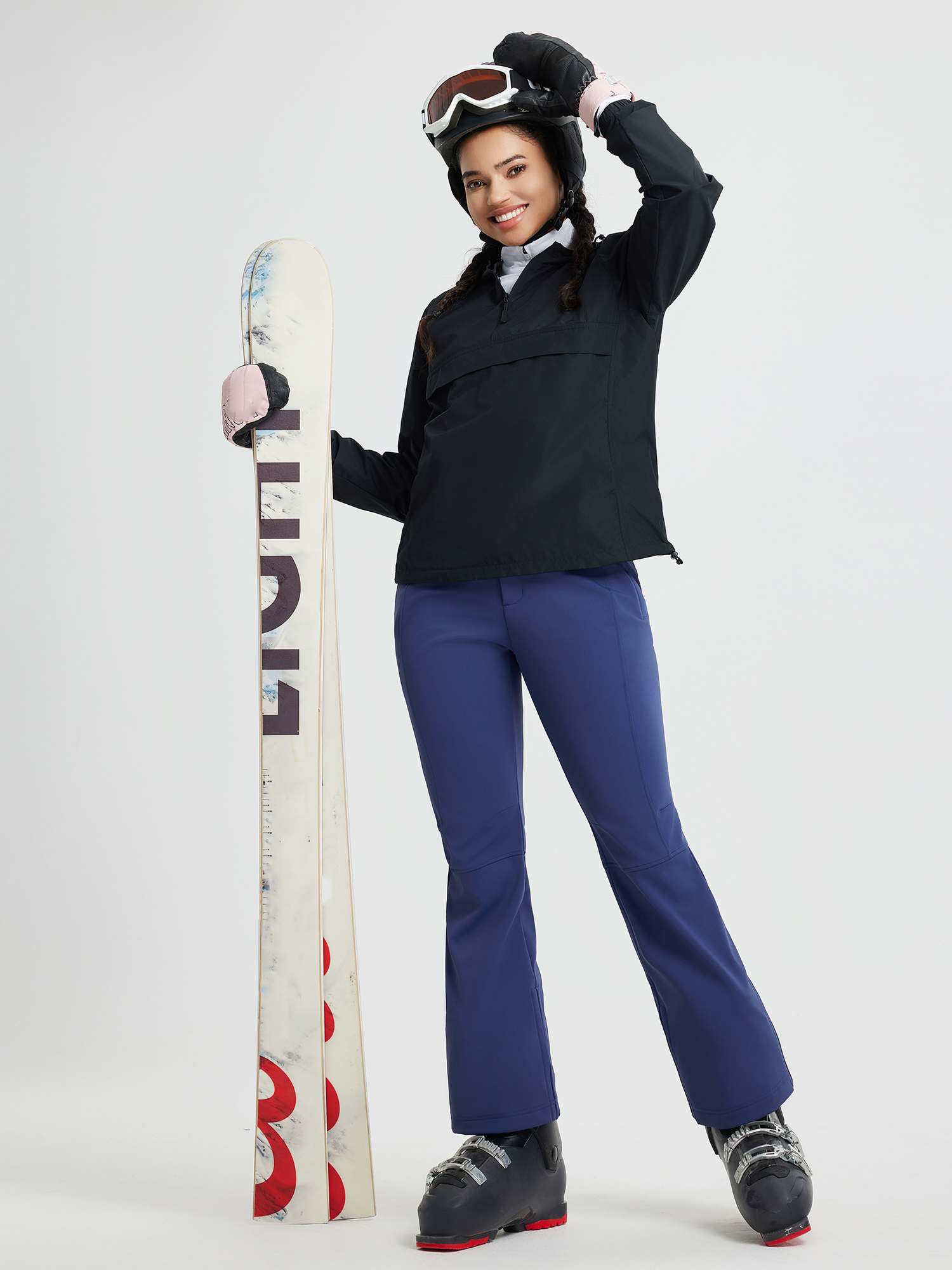 Women's blue softshell ski pants with a slightly flared leg, holding snowboard. #color_Navy Blue