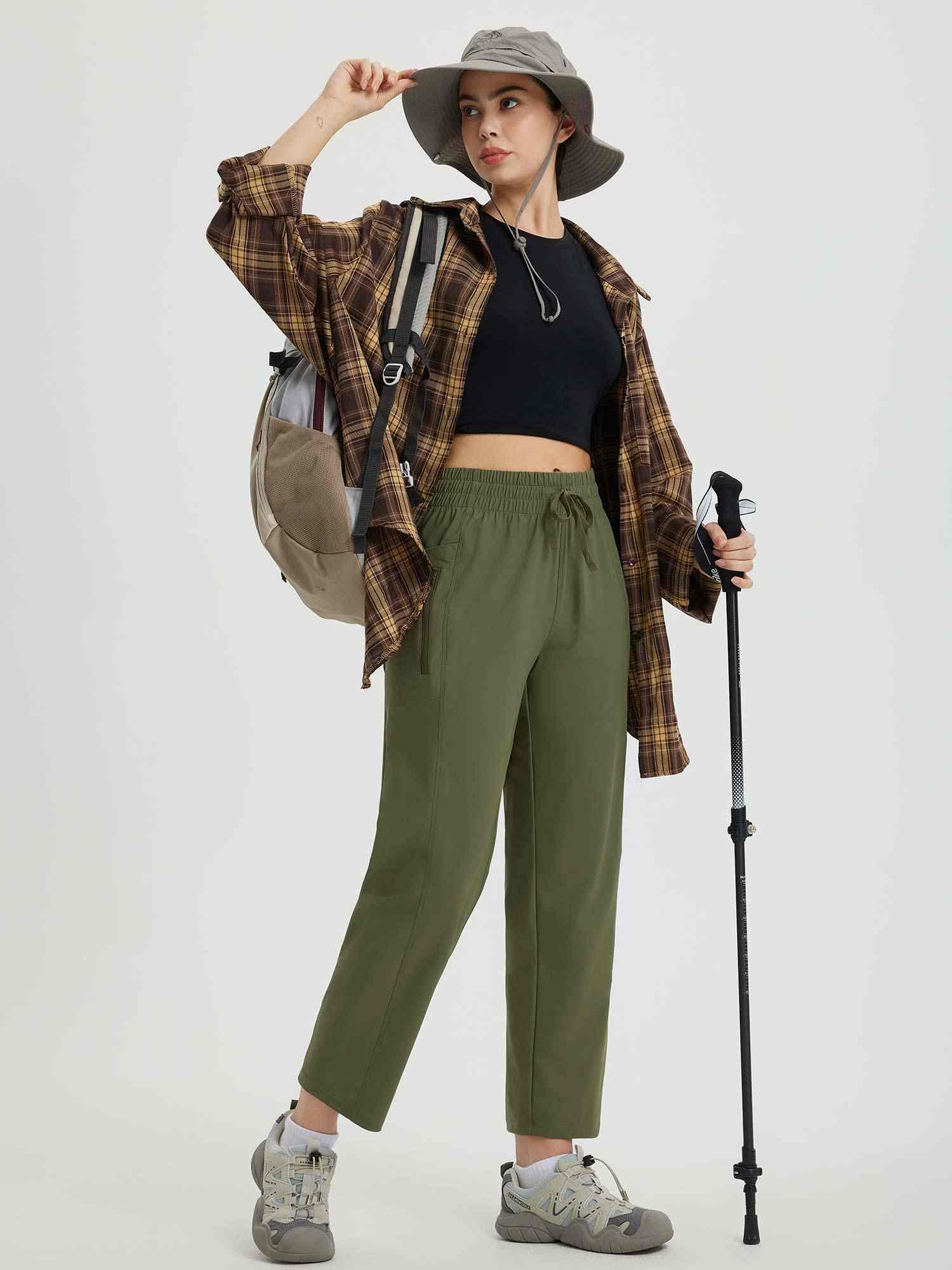 Olive green women's running sweatpants styled with hiking gear, featuring drawstring waist. #color_Army Green