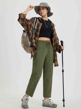 Olive green women's running sweatpants styled with hiking gear, featuring drawstring waist. #color_Army Green