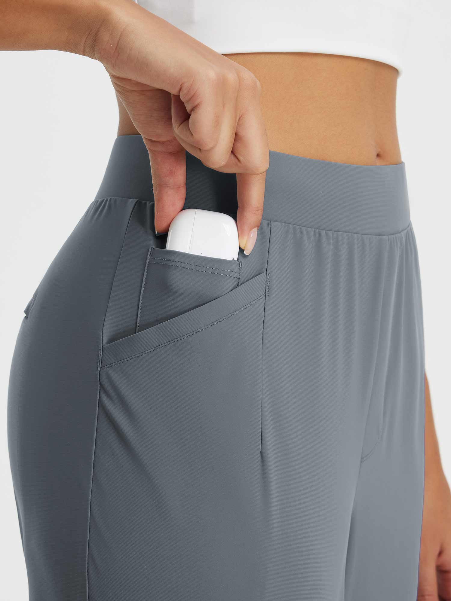 Grey high-rise tapered trousers with pocket detail for earbuds, ideal for everyday wear & travel.