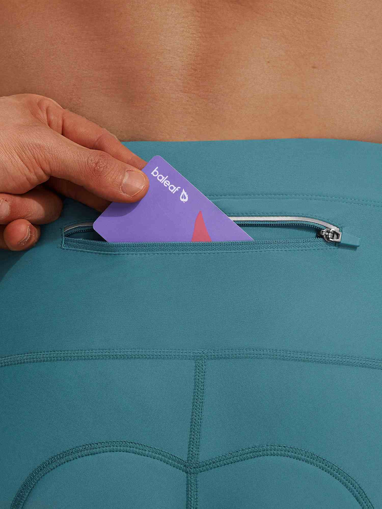 Teal Baleaf bike shorts with zippered pocket holding a Baleaf card. #color_Teal Green