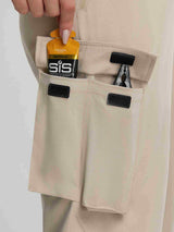 Baleaf beige ripstop hiking pants with cargo pockets holding SiS energy gel and pliers. #color_Khaki