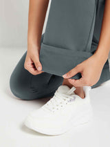 Grey fleece flare pants demonstrating soft lining and cuffed hem, worn with white sneaker.