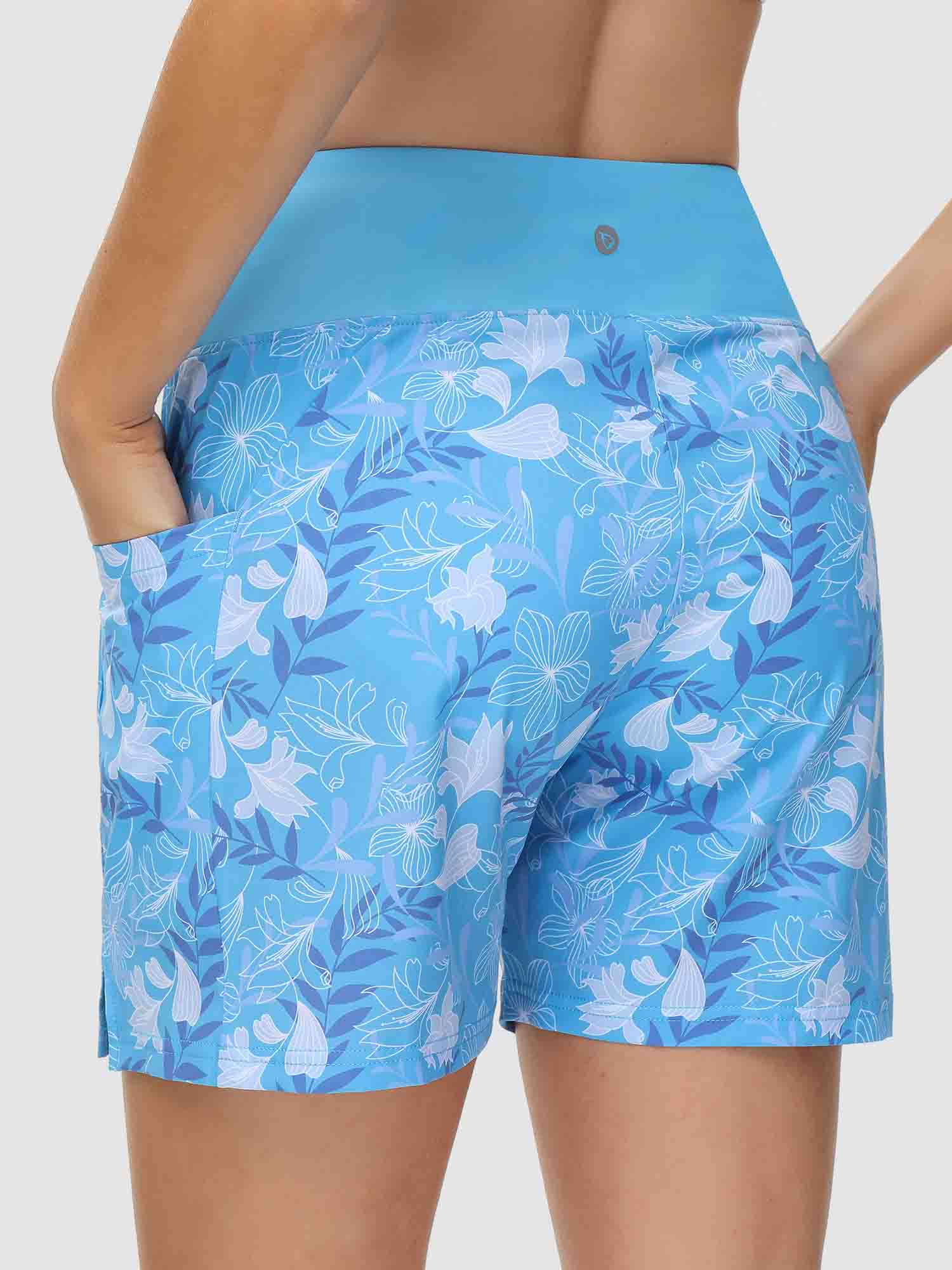 Women's blue 5-inch board shorts with white floral print, high waist, and pockets. #color_Print 2