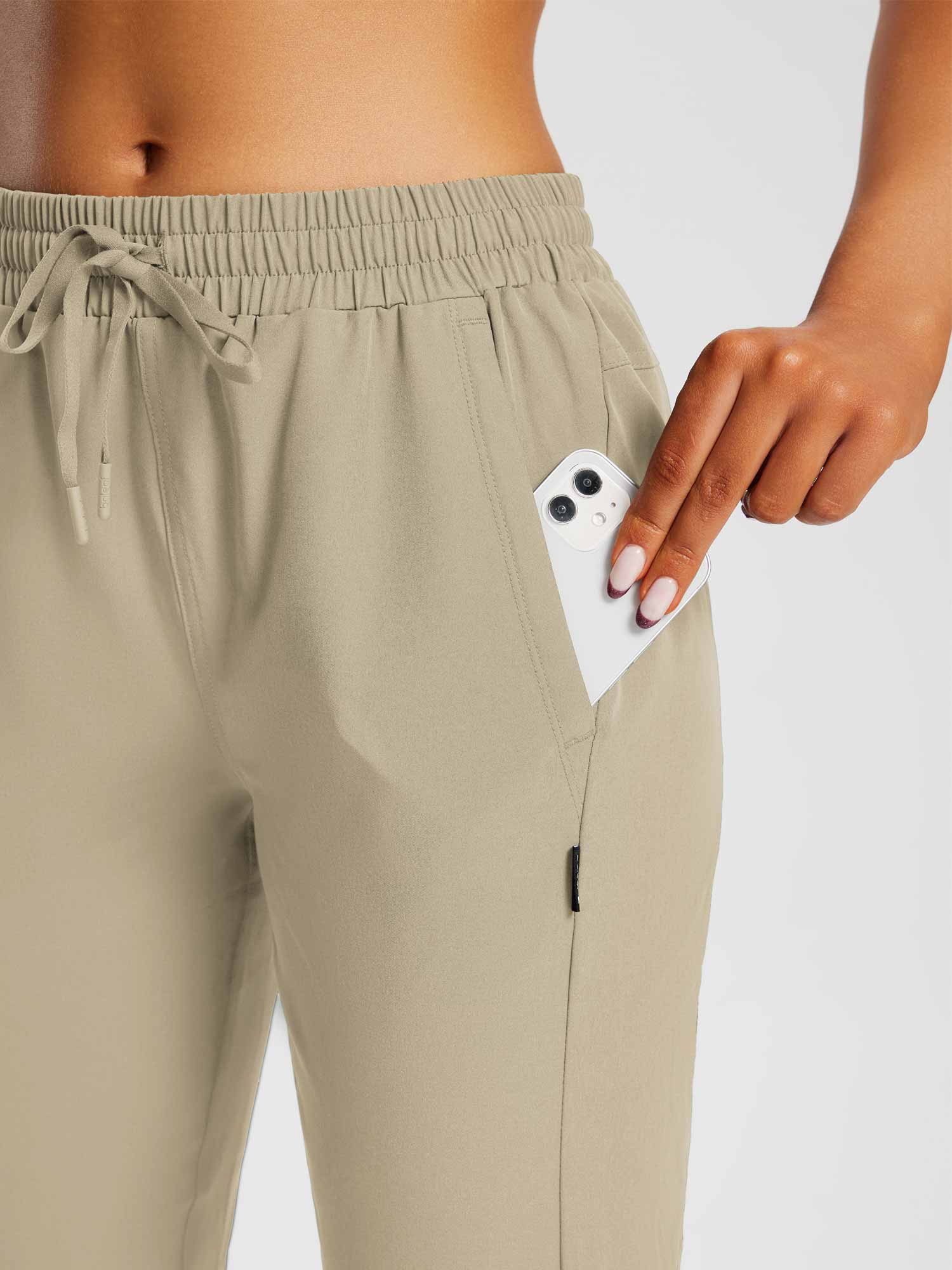 Beige pocketed capris for everyday outdoor comfort, hand placing phone in pocket. #color_Doeskin