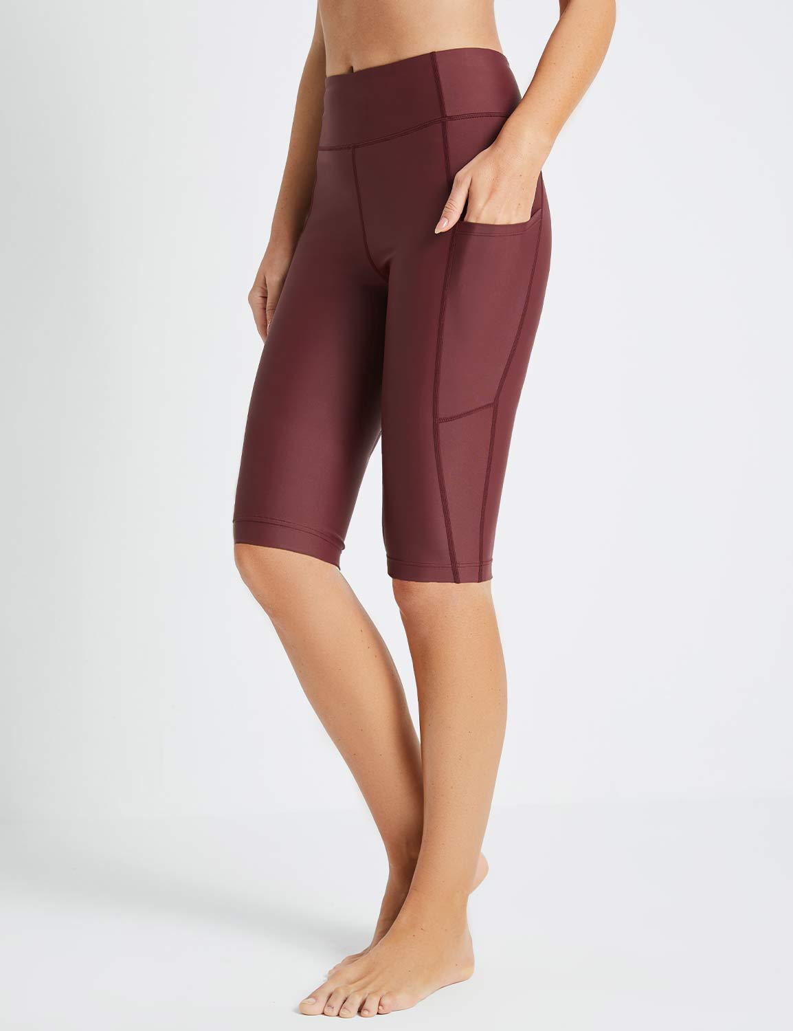 Baleaf Flyleaf UPF50+ maroon high-rise swim shorts with pockets on a woman's legs.