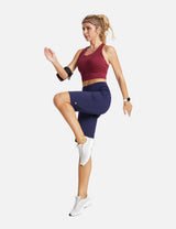 Woman in navy high-waisted running shorts and burgundy sports bra in motion